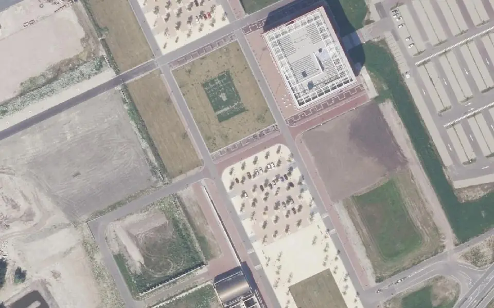 Luchtfoto 2016 van dezelfde plek: lege bouwkavels en parkeerterreinen.